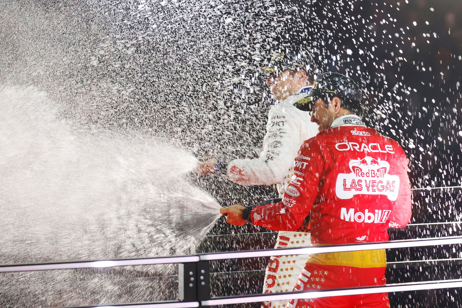 Sergio Perez and Max Verstappen celebrate on the podium after the 2023 Las Vegas Formula 1 Grand Prix