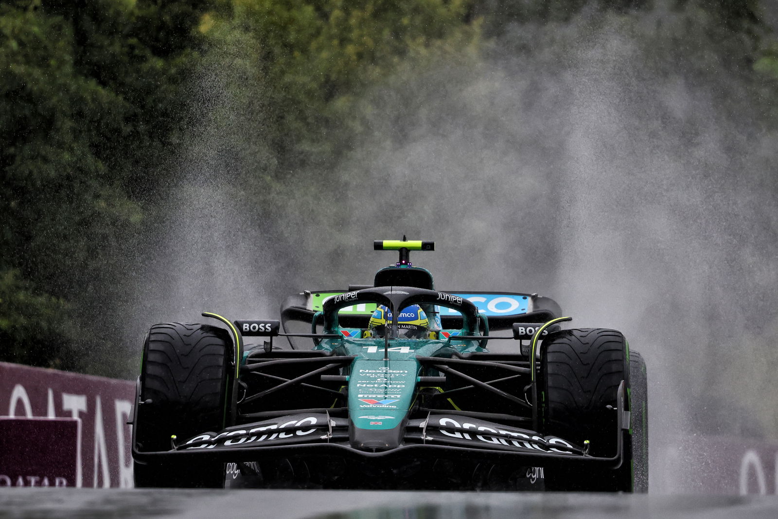 An Aston Martin F1 car driving in the wet