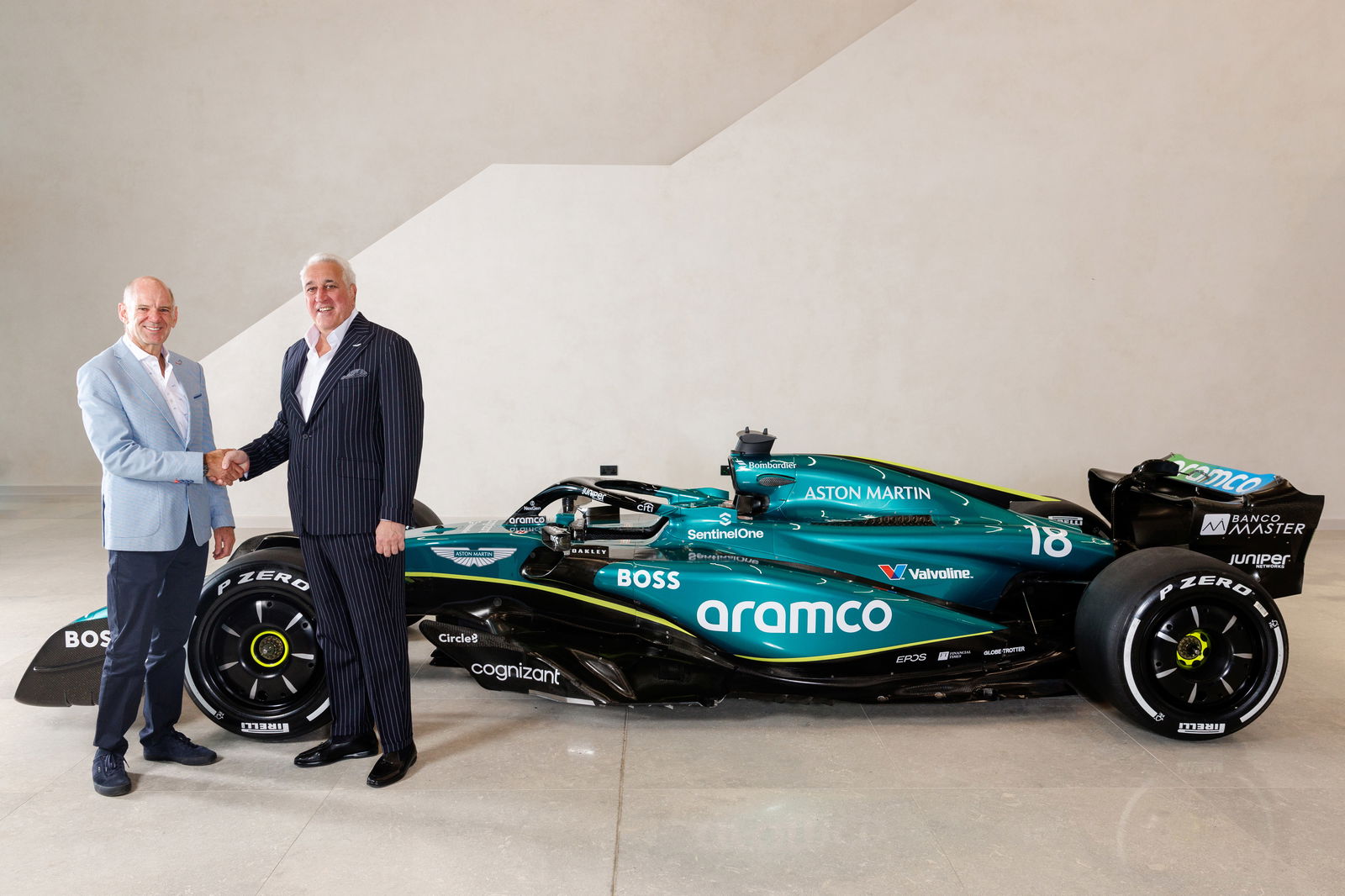 Newey and Stroll shake hands at the Aston Martin Factory. 