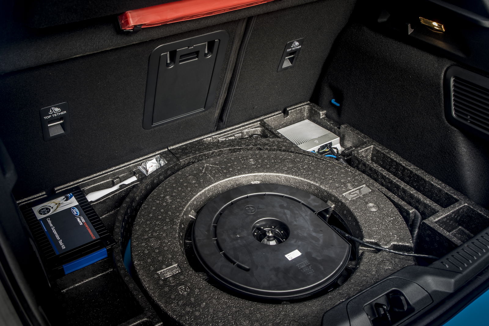 A tool kit for suspension adjustment sits under the boot floor