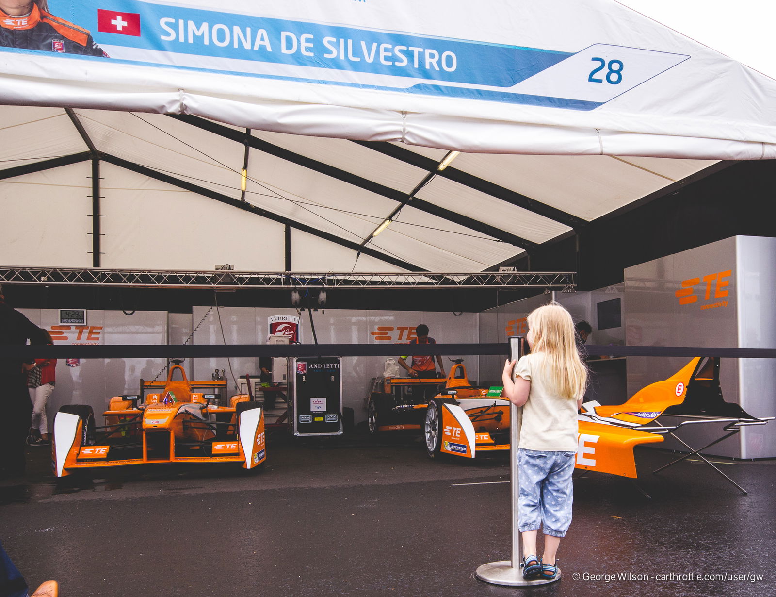 A young girl gazes into the garage of Simona De Silvestro, the only female driver in the series