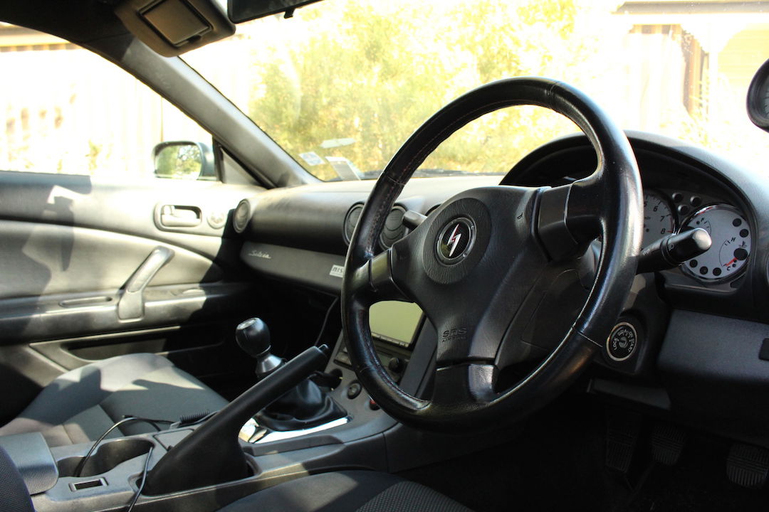 A messy JDM S15 interior, note the badge on the steering wheel