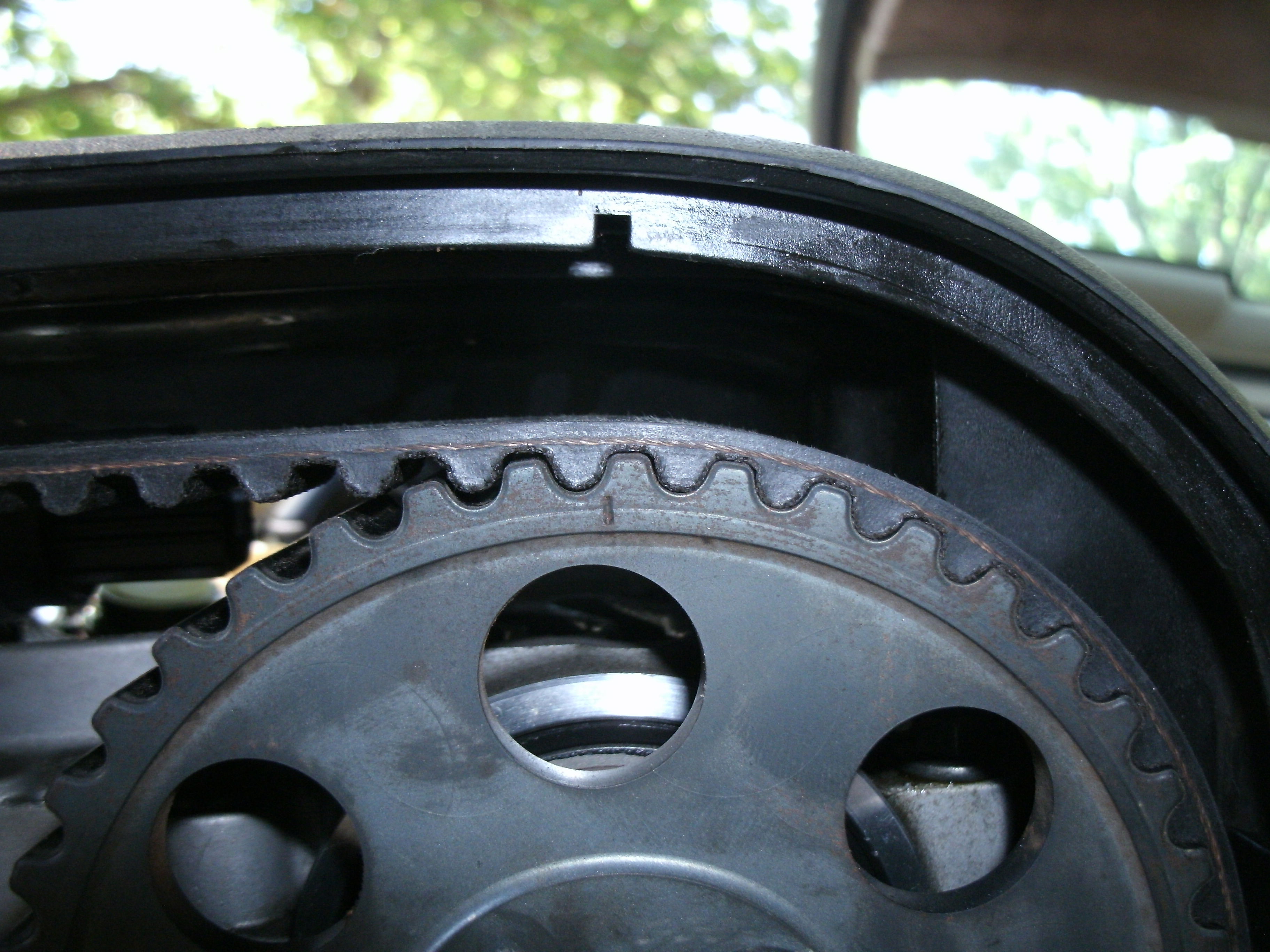 A timing mark on a cam sprocket properly aligned with its respective valve cover mark