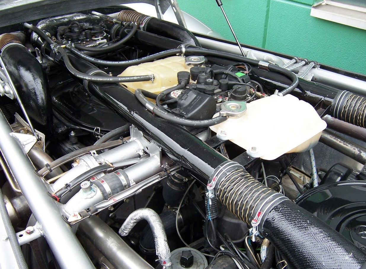 The two V8s under the endless hood, covered in pipes and wires