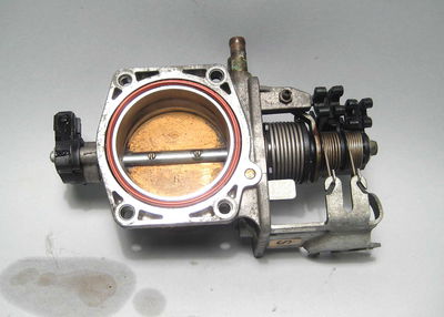 A throttle body from a BMW M52 engine, showing clearly the return springs used to shut the butterfly valve once the throttle is closed