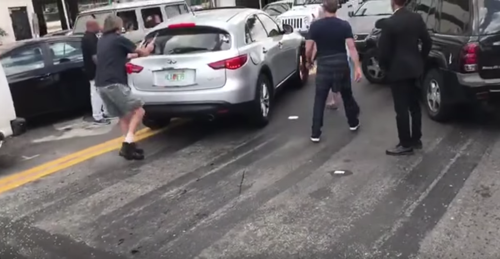 One bystander attacked the fleeing Infiniti with a hammer